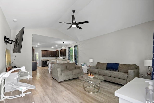 living room with ceiling fan, light hardwood / wood-style flooring, and lofted ceiling