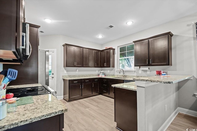 kitchen with light hardwood / wood-style floors, light stone countertops, dark brown cabinetry, and sink