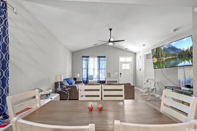 dining room featuring ceiling fan, vaulted ceiling, and wood-type flooring