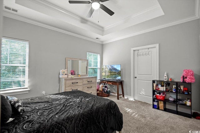 carpeted bedroom featuring ceiling fan, a tray ceiling, and multiple windows