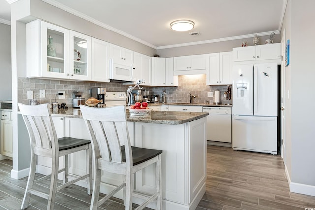 kitchen featuring light stone countertops, white appliances, white cabinets, and kitchen peninsula