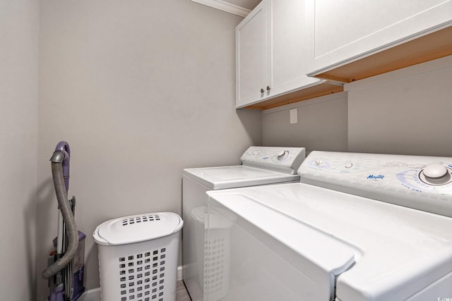 laundry room featuring separate washer and dryer, cabinets, and crown molding