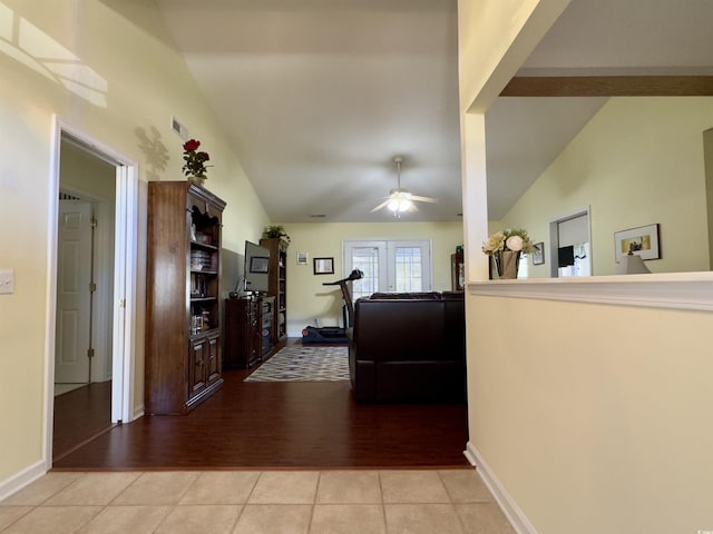 hall with light tile patterned floors, french doors, and vaulted ceiling