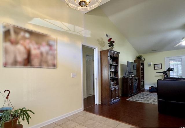 interior space featuring lofted ceiling and ceiling fan with notable chandelier