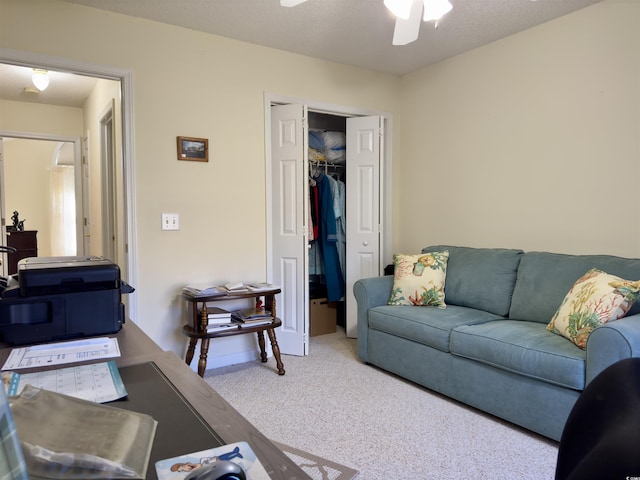 living room featuring light carpet, ceiling fan, and a textured ceiling