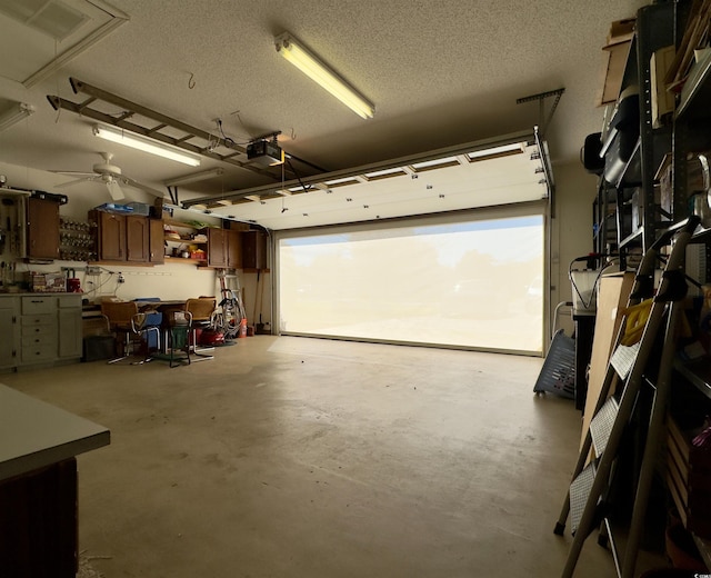 garage with ceiling fan, a workshop area, and a garage door opener