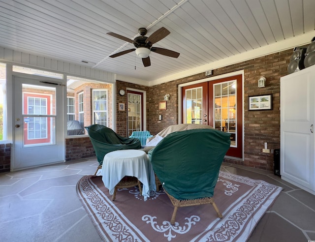 exterior space with ceiling fan, french doors, and brick wall