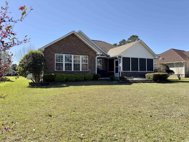 ranch-style home featuring a front yard and a sunroom