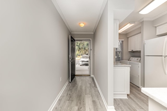 doorway to outside featuring light hardwood / wood-style floors, ornamental molding, and washing machine and dryer