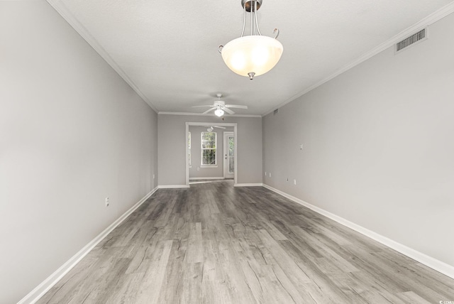 spare room featuring ceiling fan, wood-type flooring, ornamental molding, and a textured ceiling