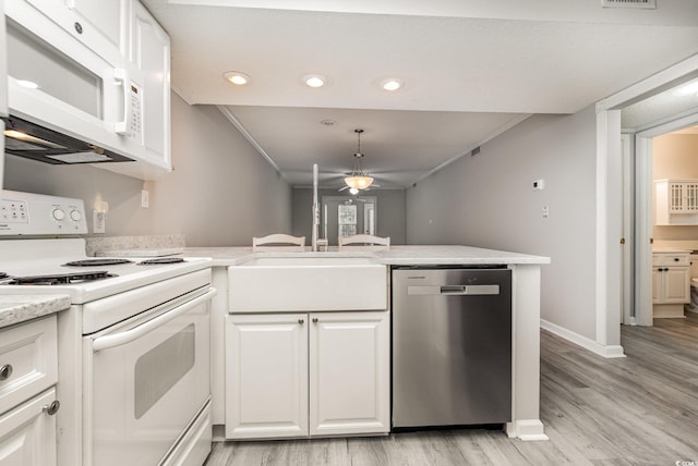 kitchen featuring pendant lighting, kitchen peninsula, white appliances, light wood-type flooring, and white cabinets