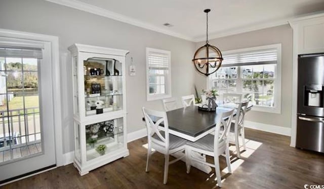 dining area with dark hardwood / wood-style floors, ornamental molding, and an inviting chandelier