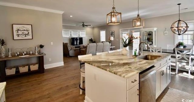 kitchen featuring decorative light fixtures, white cabinetry, sink, a kitchen island with sink, and stainless steel dishwasher