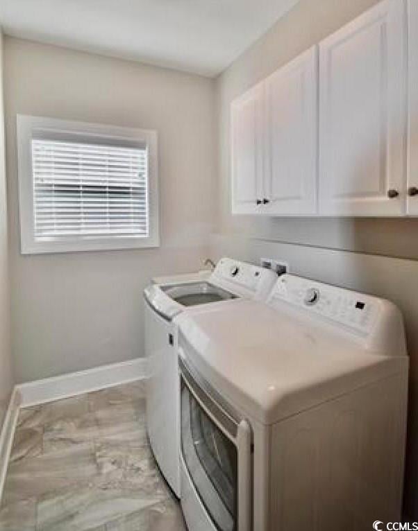 washroom featuring cabinets and separate washer and dryer