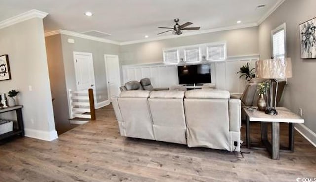 living room with ceiling fan, ornamental molding, and light hardwood / wood-style flooring