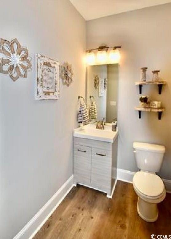 bathroom featuring toilet, wood-type flooring, and vanity