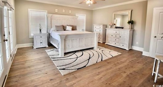 bedroom with ceiling fan, dark wood-type flooring, and ornamental molding