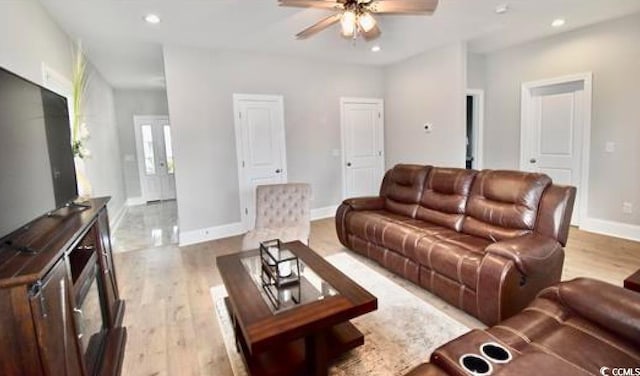 living room with ceiling fan and light hardwood / wood-style flooring