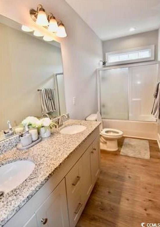 full bathroom with toilet, vanity, shower / bath combination, and hardwood / wood-style floors