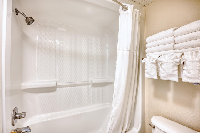 bathroom featuring toilet and shower / bath combo with shower curtain