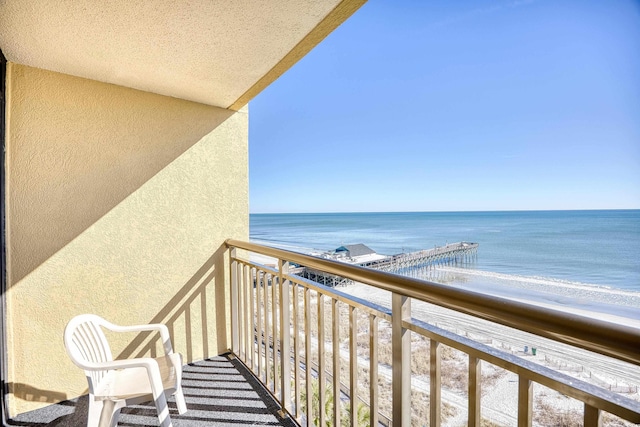 balcony featuring a water view and a view of the beach