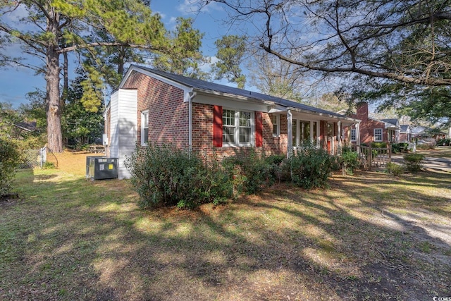 view of front of home with a porch, central AC unit, and a front yard