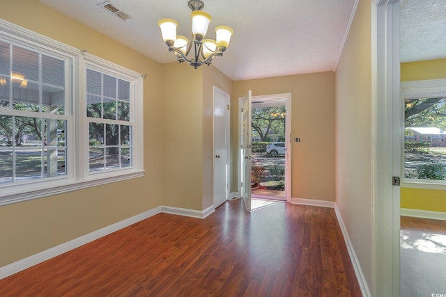 entryway featuring a chandelier, a textured ceiling, and dark hardwood / wood-style flooring