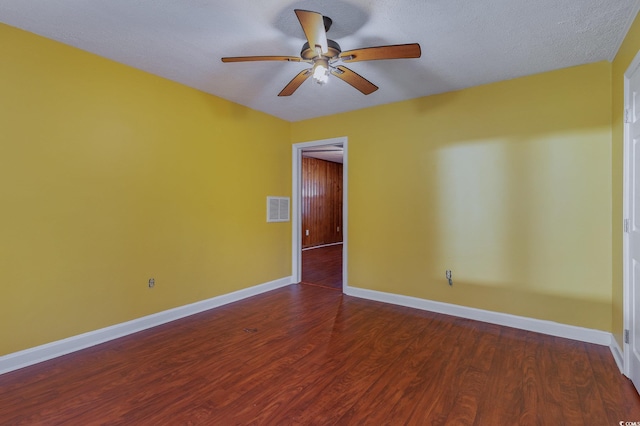 spare room with dark hardwood / wood-style floors, a textured ceiling, and ceiling fan