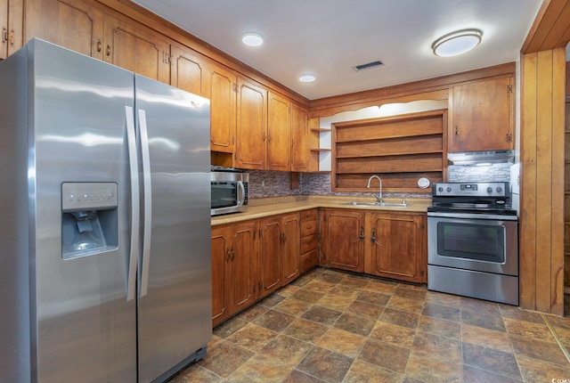 kitchen with tasteful backsplash, appliances with stainless steel finishes, and sink