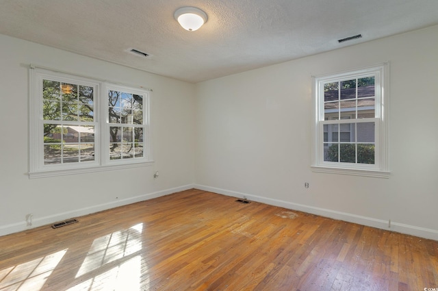 spare room featuring a textured ceiling and light wood-type flooring