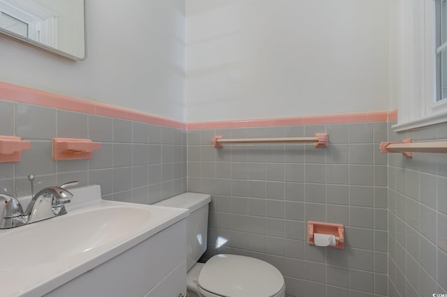 bathroom with vanity, tile walls, and toilet