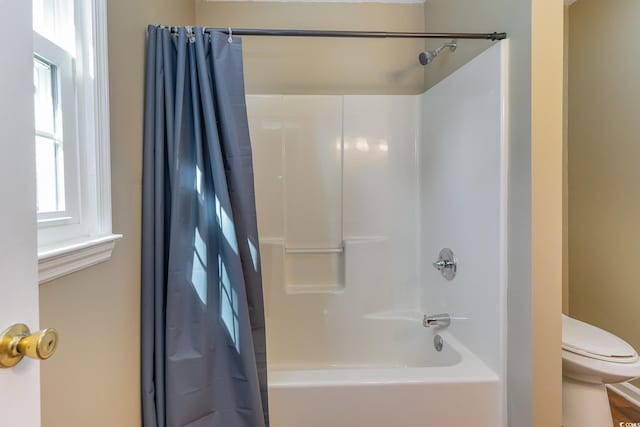 bathroom with toilet and shower / bath combo with shower curtain