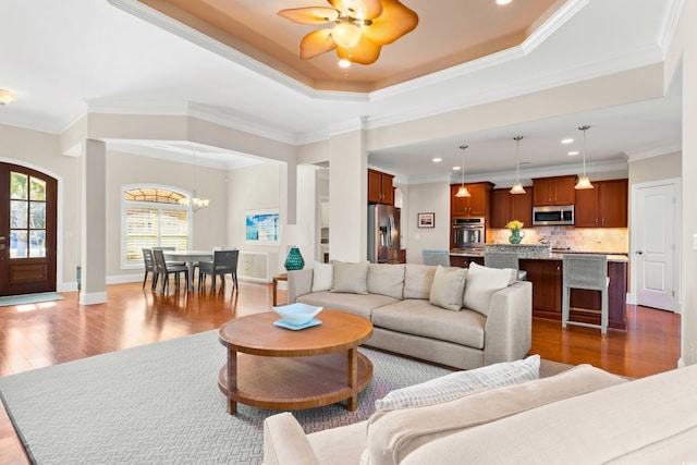 living room featuring a tray ceiling and crown molding