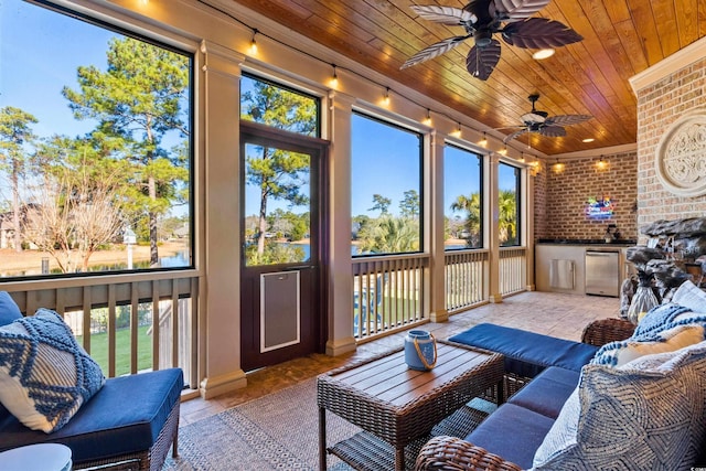 sunroom with ceiling fan, a healthy amount of sunlight, and wooden ceiling