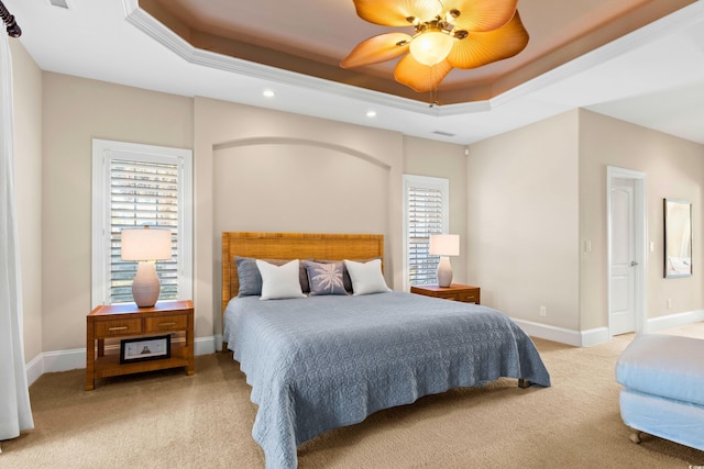 bedroom featuring ceiling fan, light colored carpet, and a raised ceiling