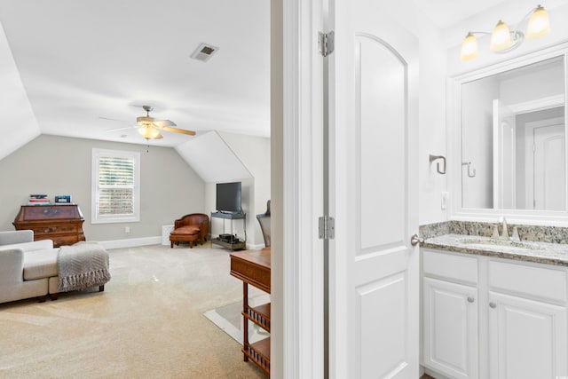 bathroom with ceiling fan, vanity, and lofted ceiling