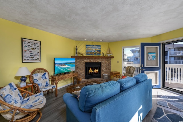 living room featuring a brick fireplace, hardwood / wood-style floors, and a textured ceiling