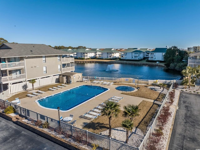 view of swimming pool with a patio area and a water view