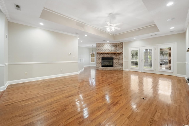 unfurnished living room featuring ceiling fan, crown molding, and a tray ceiling