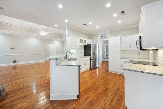 kitchen featuring stainless steel appliances, white cabinetry, backsplash, and sink