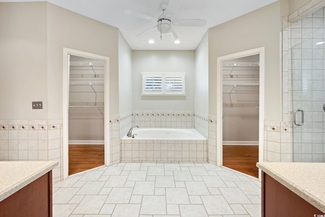 bathroom featuring tile patterned floors, ceiling fan, separate shower and tub, and vanity