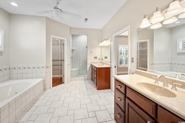 bathroom with ceiling fan with notable chandelier, vanity, tile patterned floors, and shower with separate bathtub