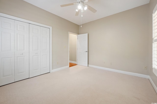 unfurnished bedroom with ceiling fan, a closet, and light carpet