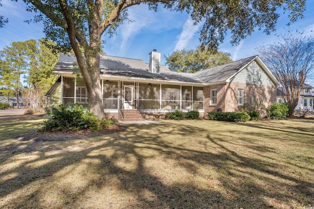 back of property with a yard and a sunroom