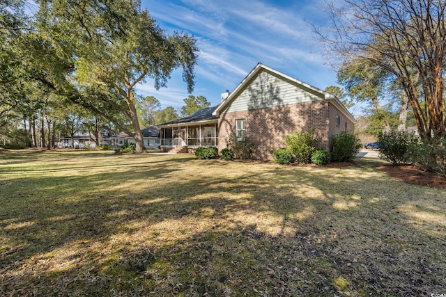 exterior space featuring a yard and a sunroom