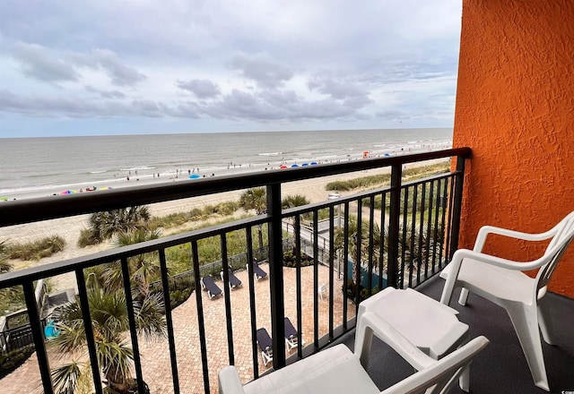 balcony featuring a view of the beach and a water view