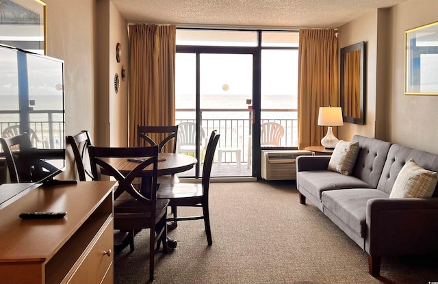 dining area with a wall mounted AC, light colored carpet, expansive windows, and a textured ceiling