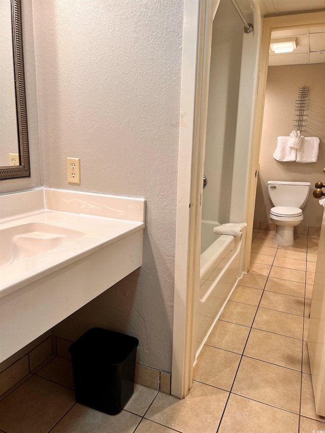 bathroom with tile patterned flooring, sink, a bathtub, and toilet