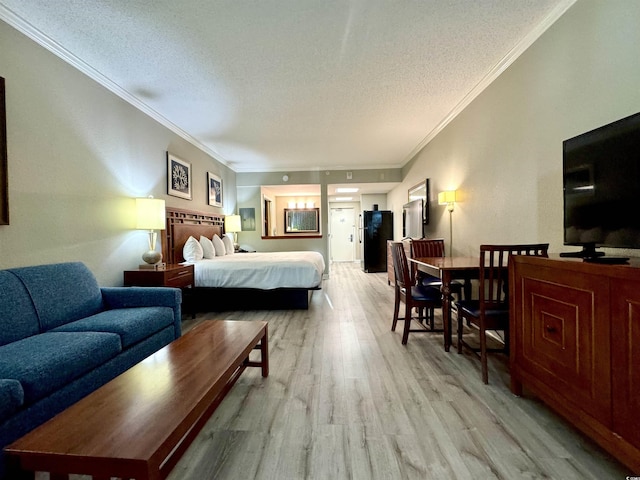 bedroom with crown molding, a textured ceiling, and light wood-type flooring