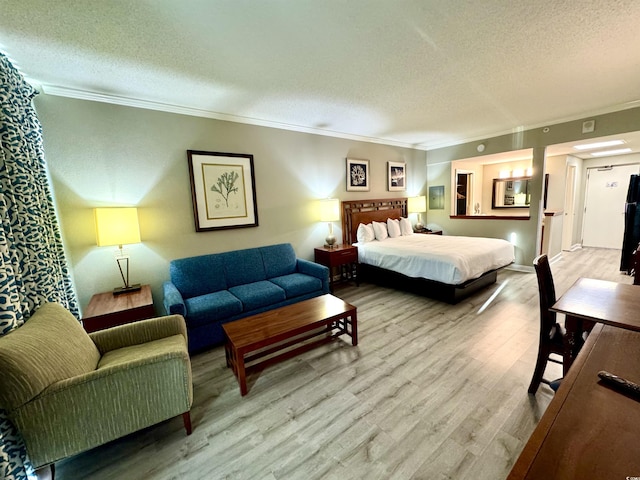 bedroom with crown molding, a textured ceiling, and light wood-type flooring